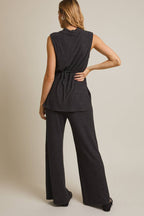 Woman wearing a heather  gray sleeveless top and pants on a beige background