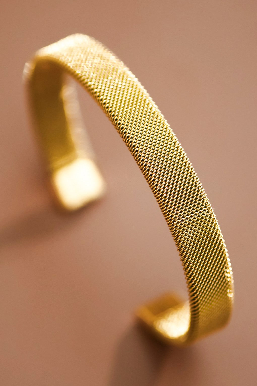 18k gold-plated mesh bracelet on a brown background