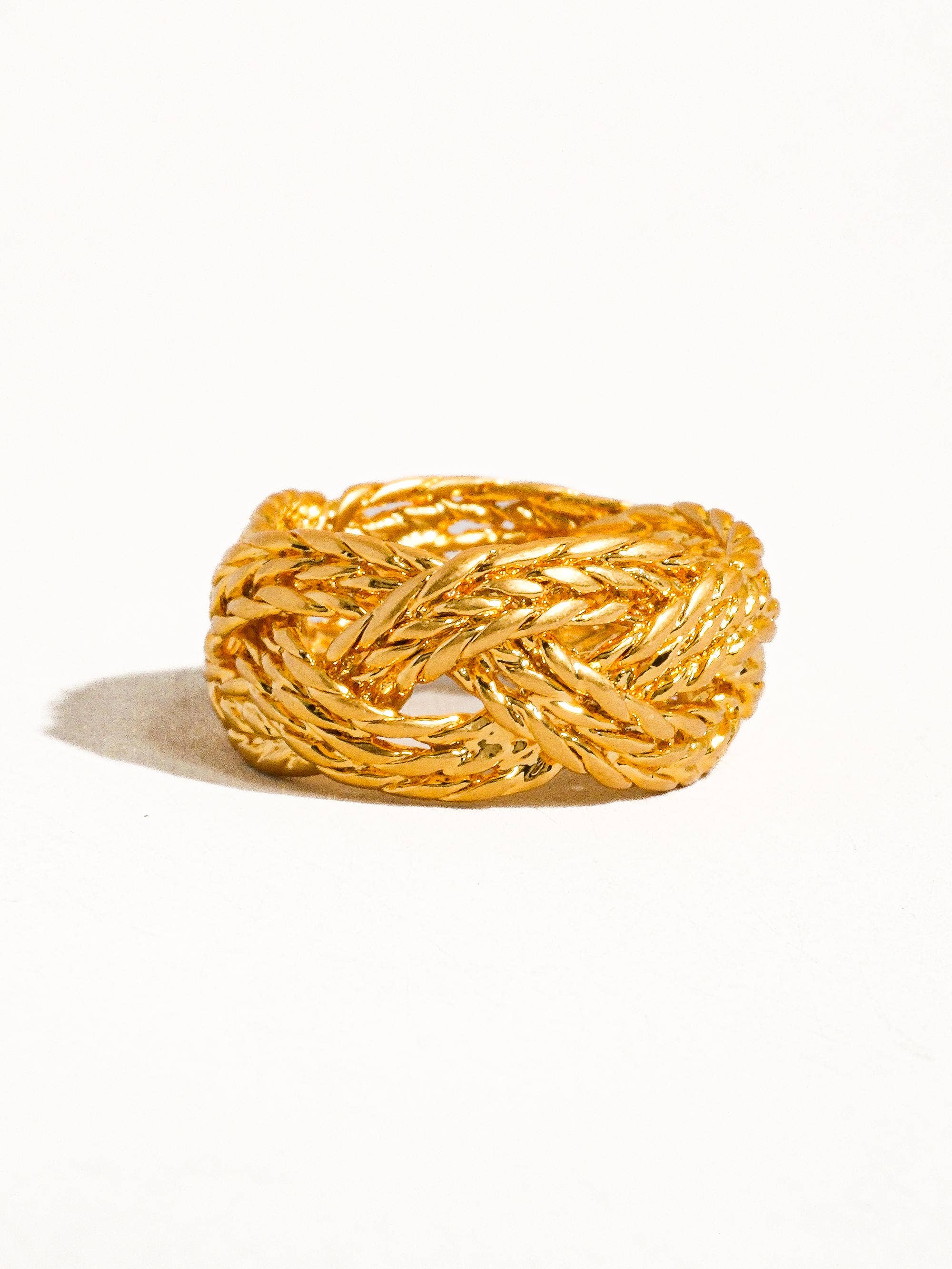 Gold braided ring on a white background
