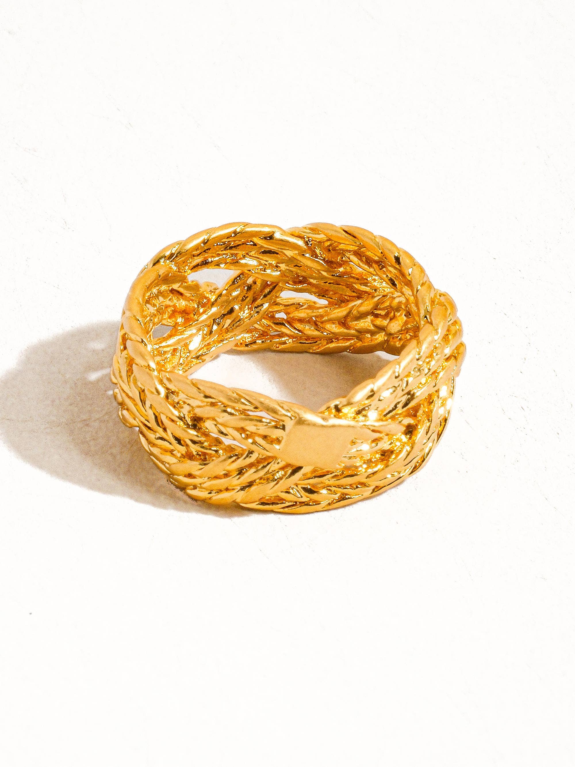 Gold braided ring on a white background