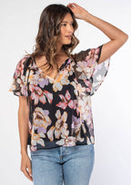 Woman wearing a floral blouse with a plain background