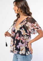 Woman wearing a floral blouse with a plain background