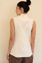 Back view of a woman wearing a cream mock neck knitted sleeveless top against a beige background