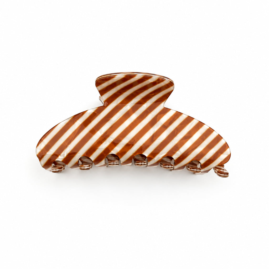 A semi-circle hair claw with diagonal copper and cream pearl stripes, shown on a clean white surface
