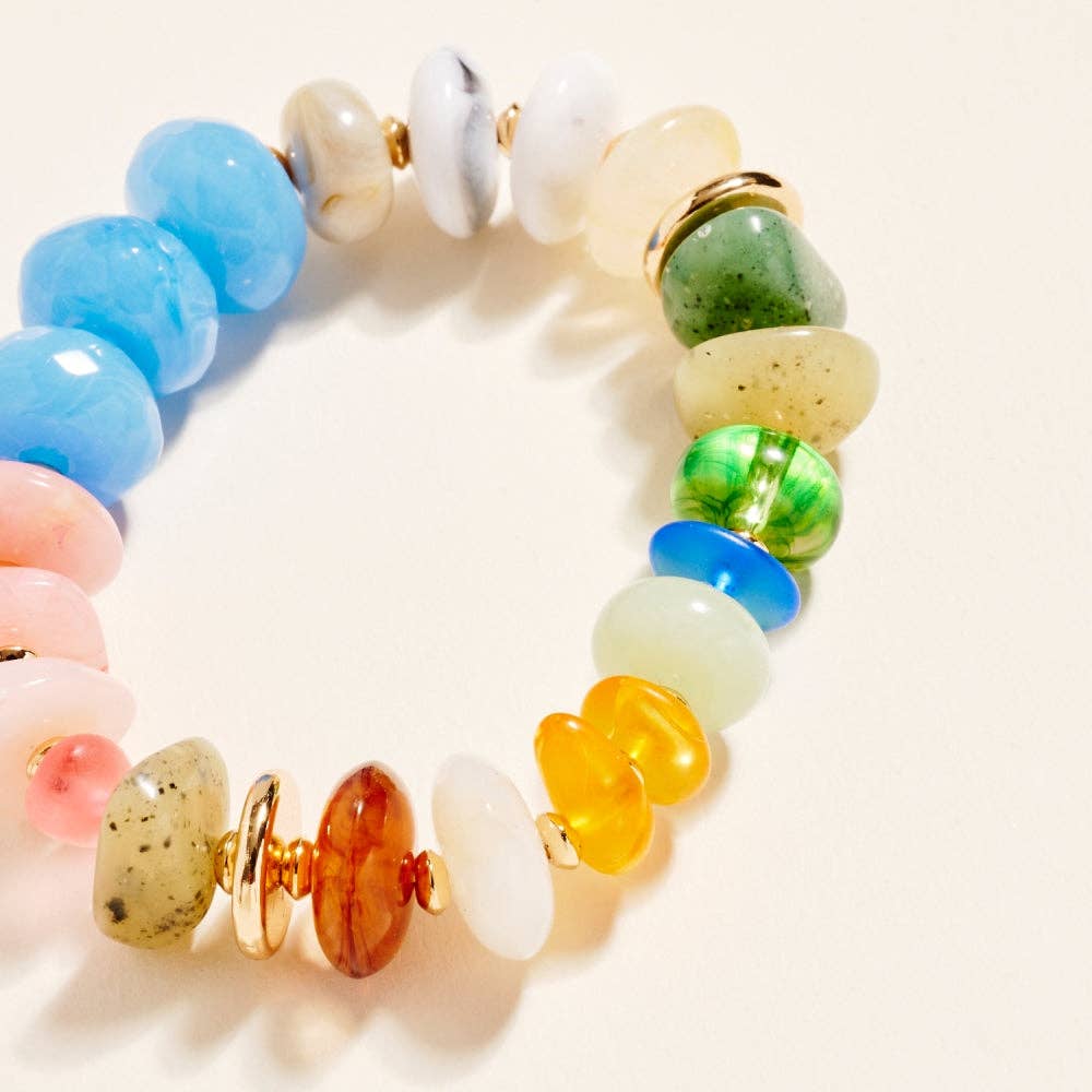 Colorful beaded bracelet with gold accents on a light background