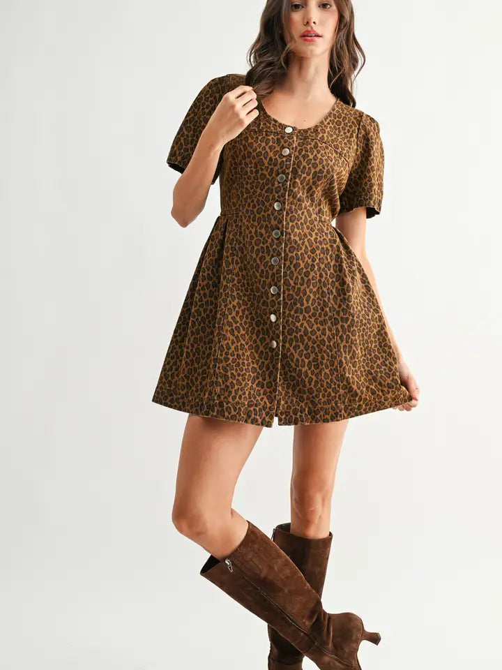 Woman wearing a leopard print dress with brown knee-high boots on a white background