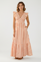 Woman wearing a coral and cream striped maxi dress on a cream background