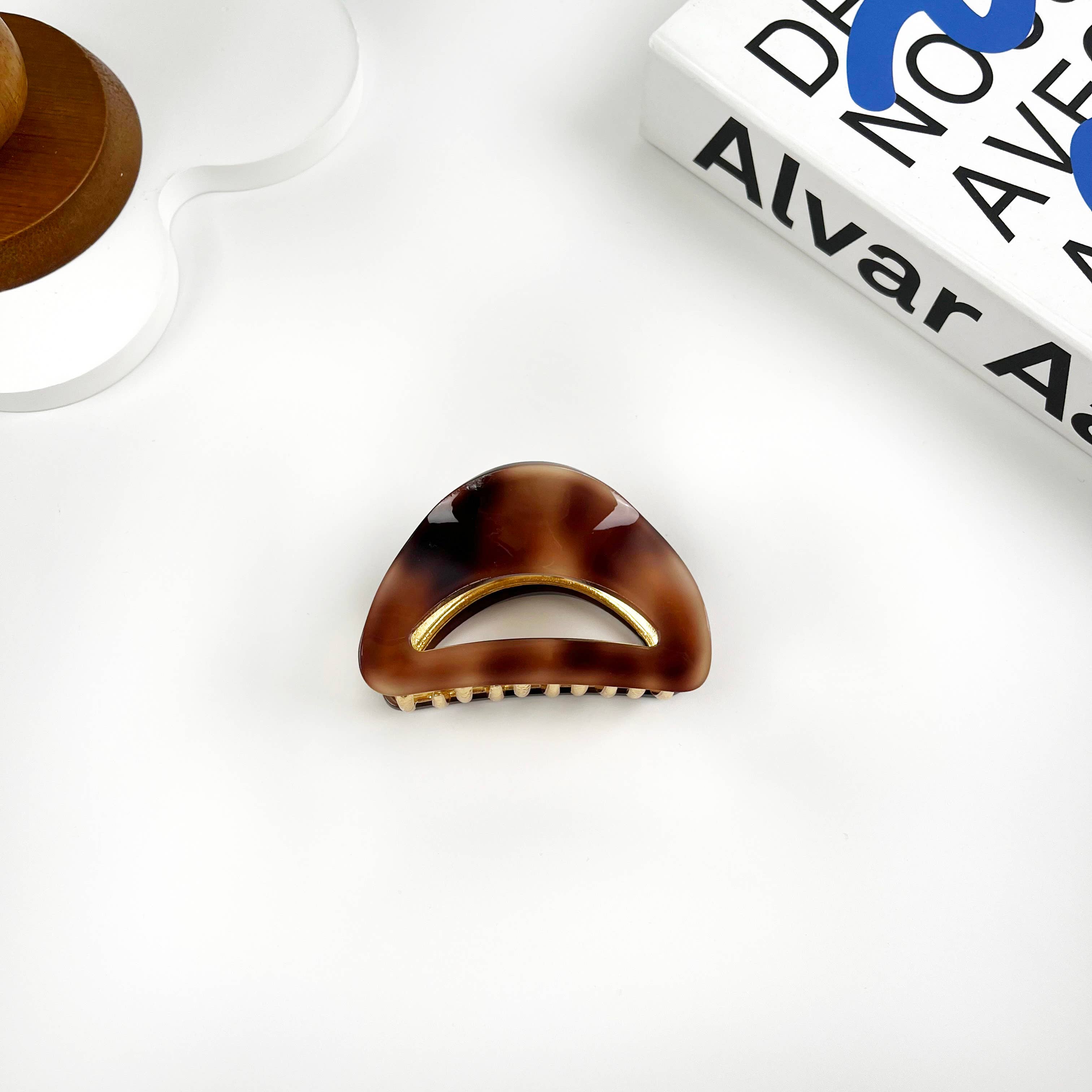 Brown tortoiseshell hair clip on a white surface