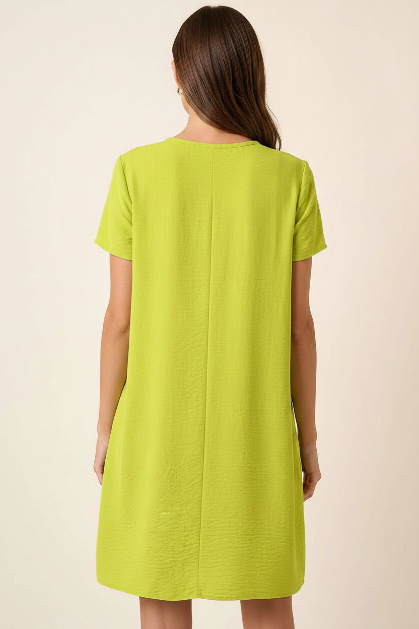 Back view of a woman wearing a lime green dress against a beige background