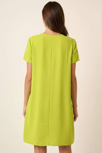 Back view of a woman wearing a lime green dress against a beige background