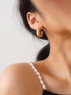 Woman wearing 18k gold-plated puffy hoop earrings 