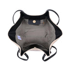 Inside fabric and pockets natural straw bag with black strap on a white background