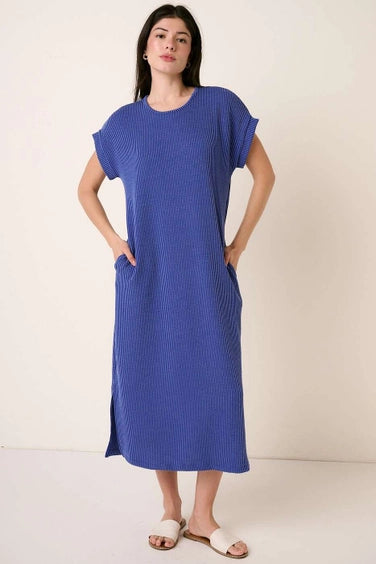 Woman wearing a royal blue midi dress on a plain background