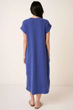 Back view of a woman wearing a royal blue midi dress on a plain background