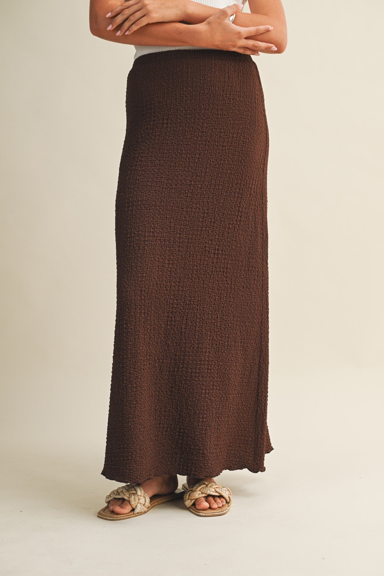 Brown bubble texture skirt worn by a woman on a beige background