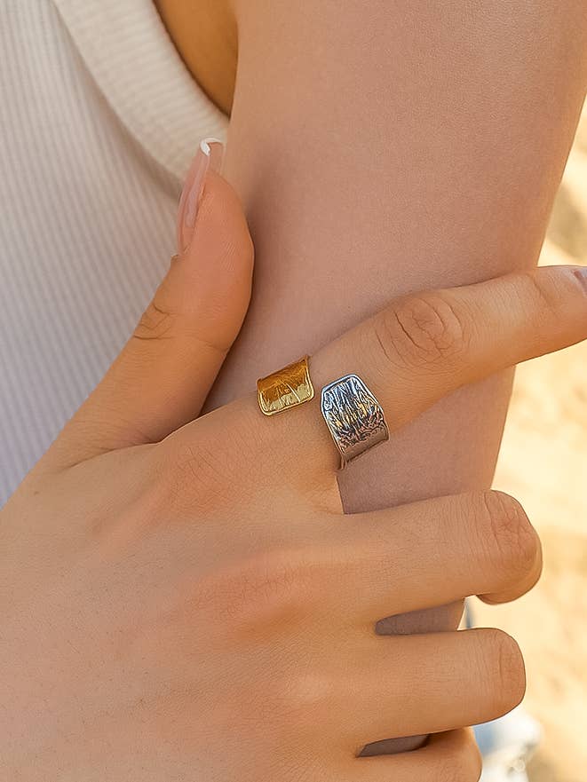 Gold and silver tone open ring on a woman's hand 