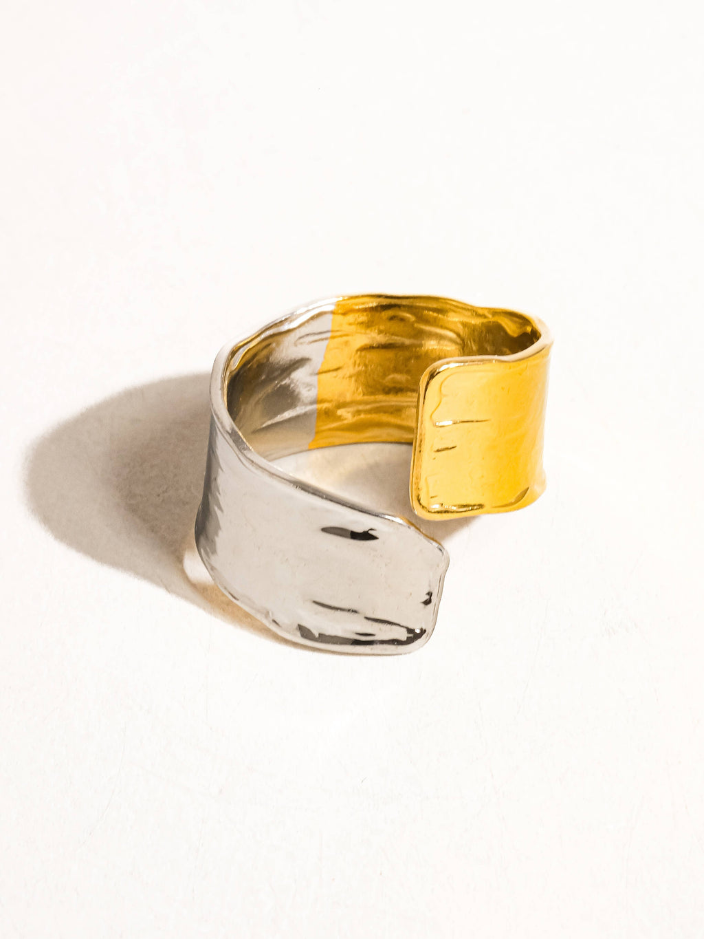 Gold and silver tone ring on a white background