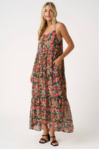 Woman wearing a floral tiered maxi dress on a white background