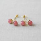 Pair of pink ball earrings with gold accents on a light gray background