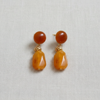 Pair of brown and gold stone look earrings on a light gray background