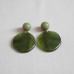 Pair of green circle earrings with a ball post on a light gray background