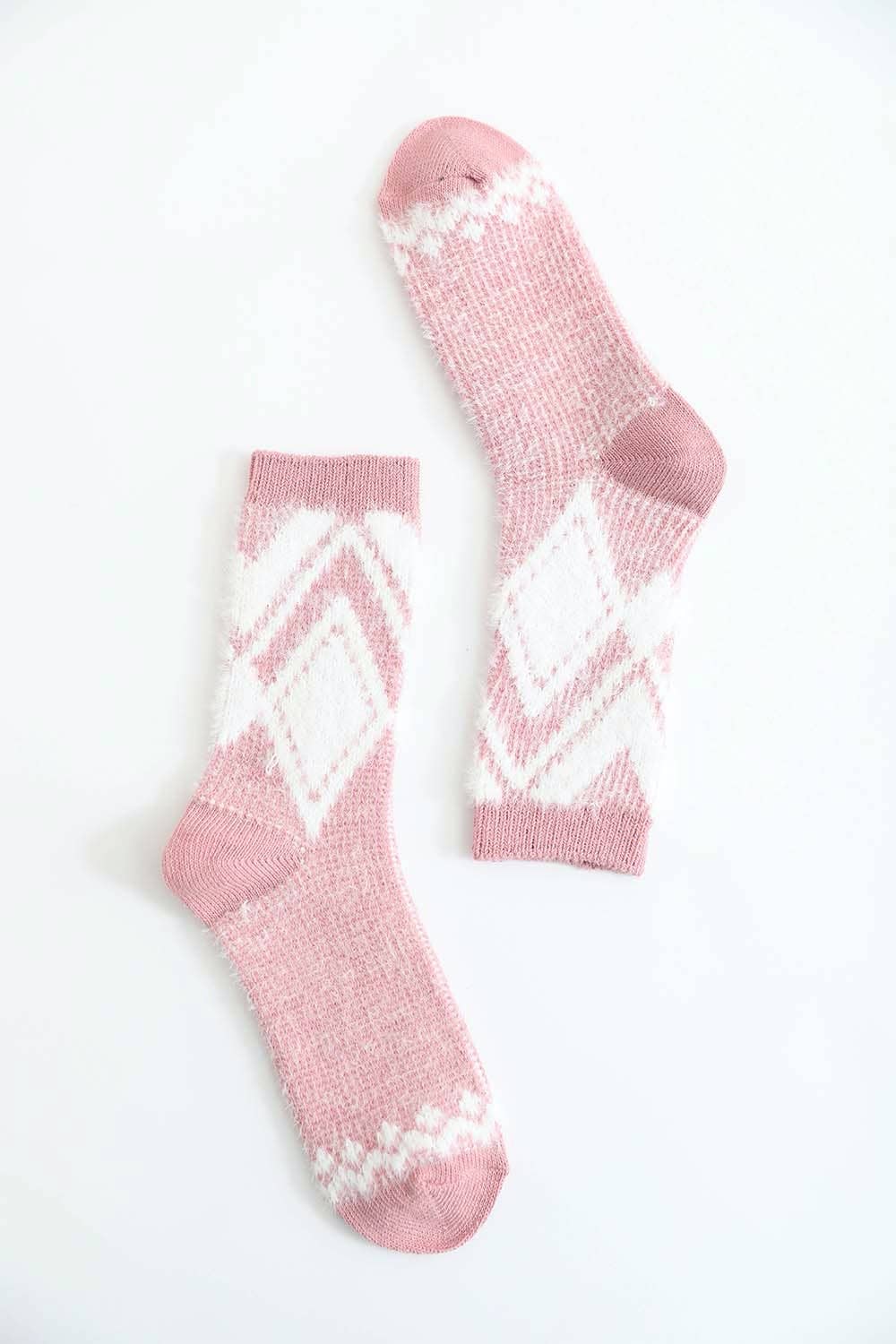 Pair of pink diamond pattern faux mohair socks with white patterns on a white background