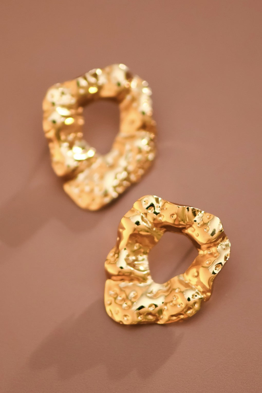 Gold nugget circle stud earrings on brown backgound