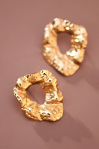 Gold nugget circle stud earrings on brown backgound