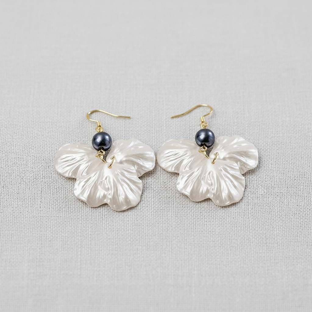 Pearl flower earrings with dark gray bead on a light gray background