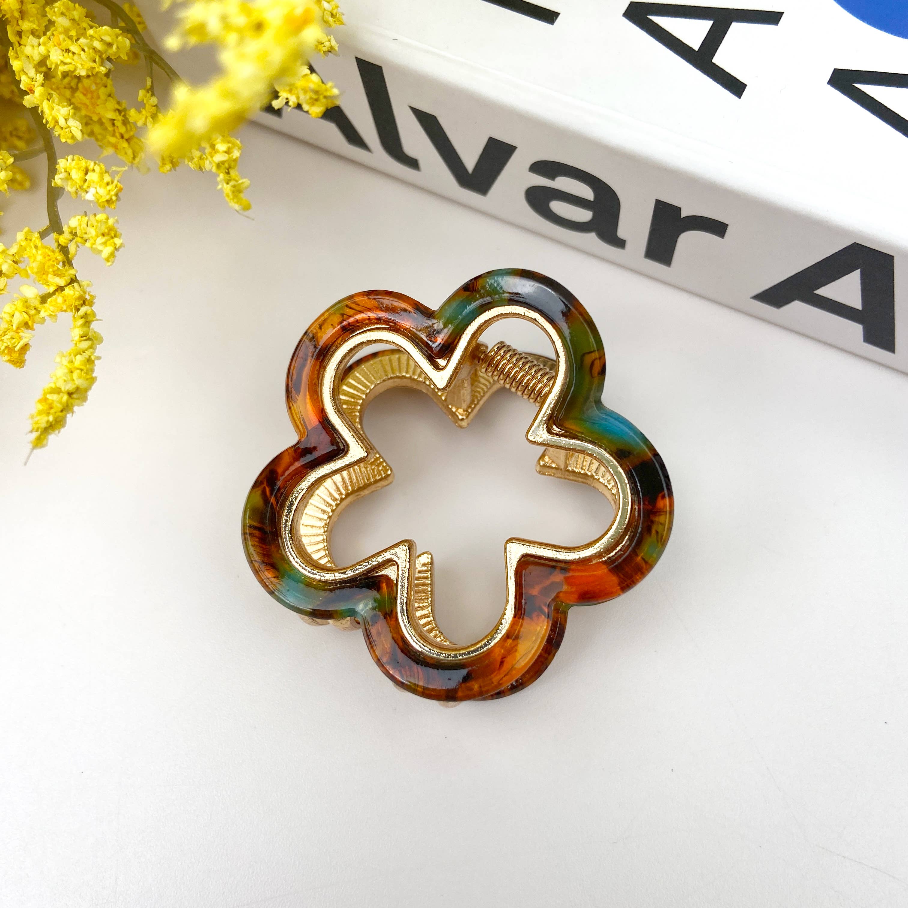 Decorative hair clip with tortoiseshell pattern on a white surface 