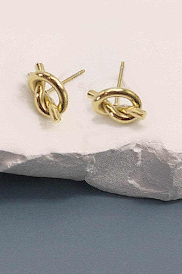 18k gold-plated stainless steel knot earrings on a stone surface