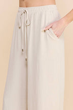 Woman wearing oatmeal wide leg pants on a beige background