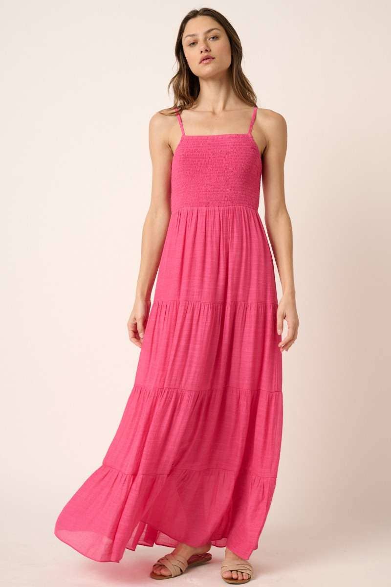 Woman wearing a hot pink dress against a plain background