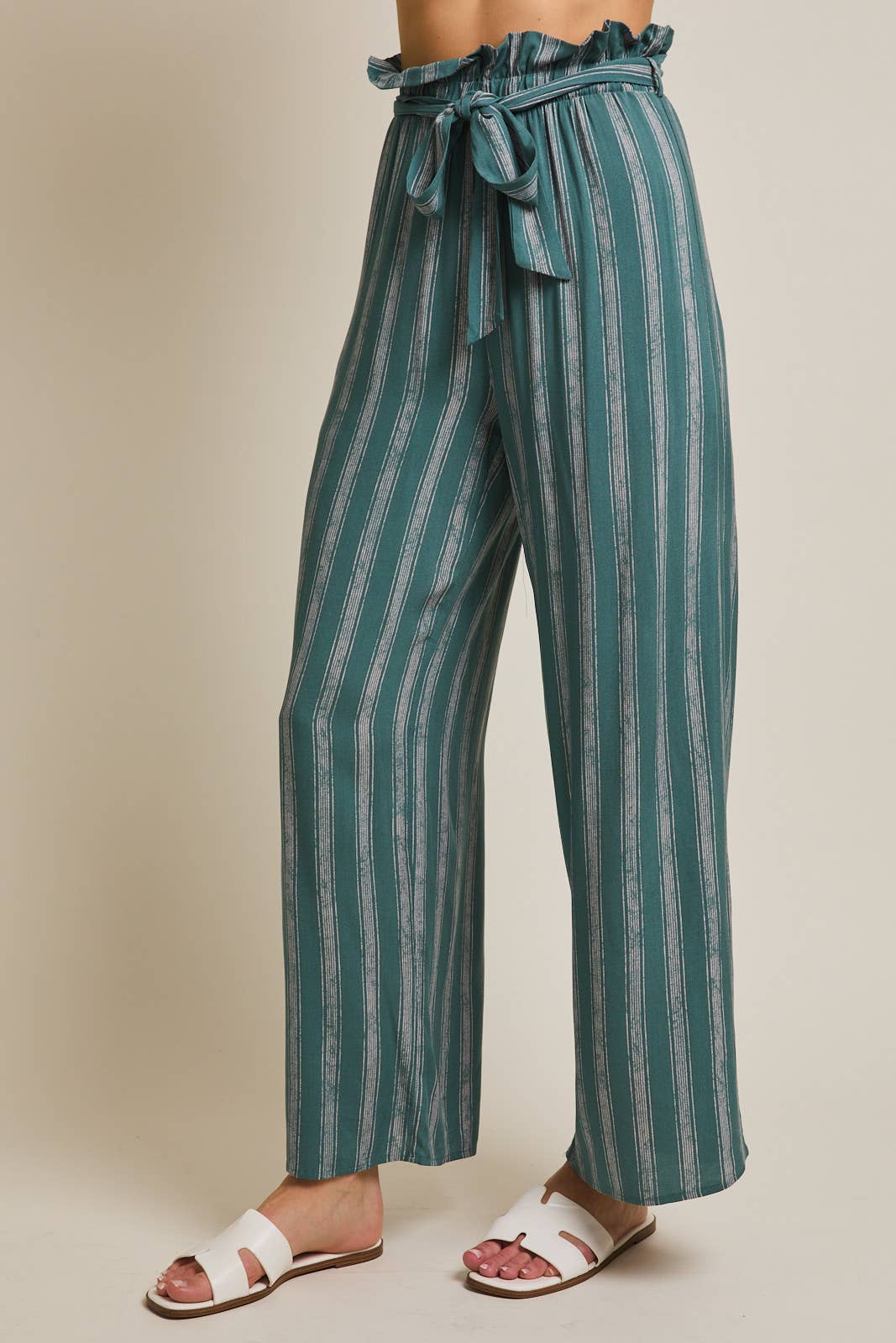 Woman wearing striped green and cream ruffle top pants with self tie