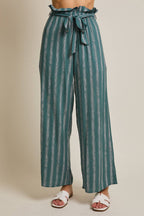 Woman wearing striped green and cream ruffle top pants with self tie