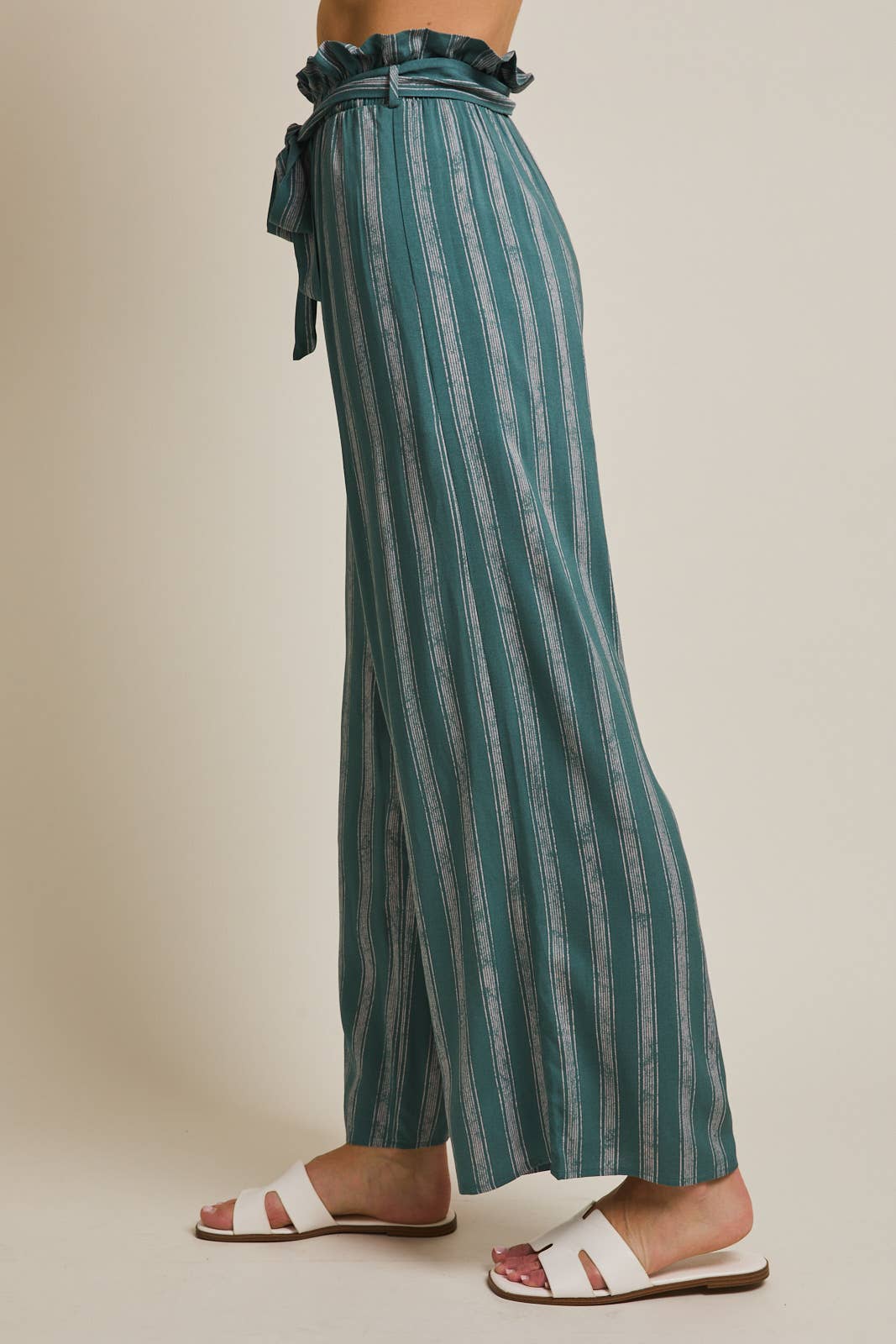 Woman wearing striped green and cream ruffle top pants with self tie