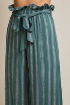 Woman wearing striped green and cream ruffle top pants with self tie