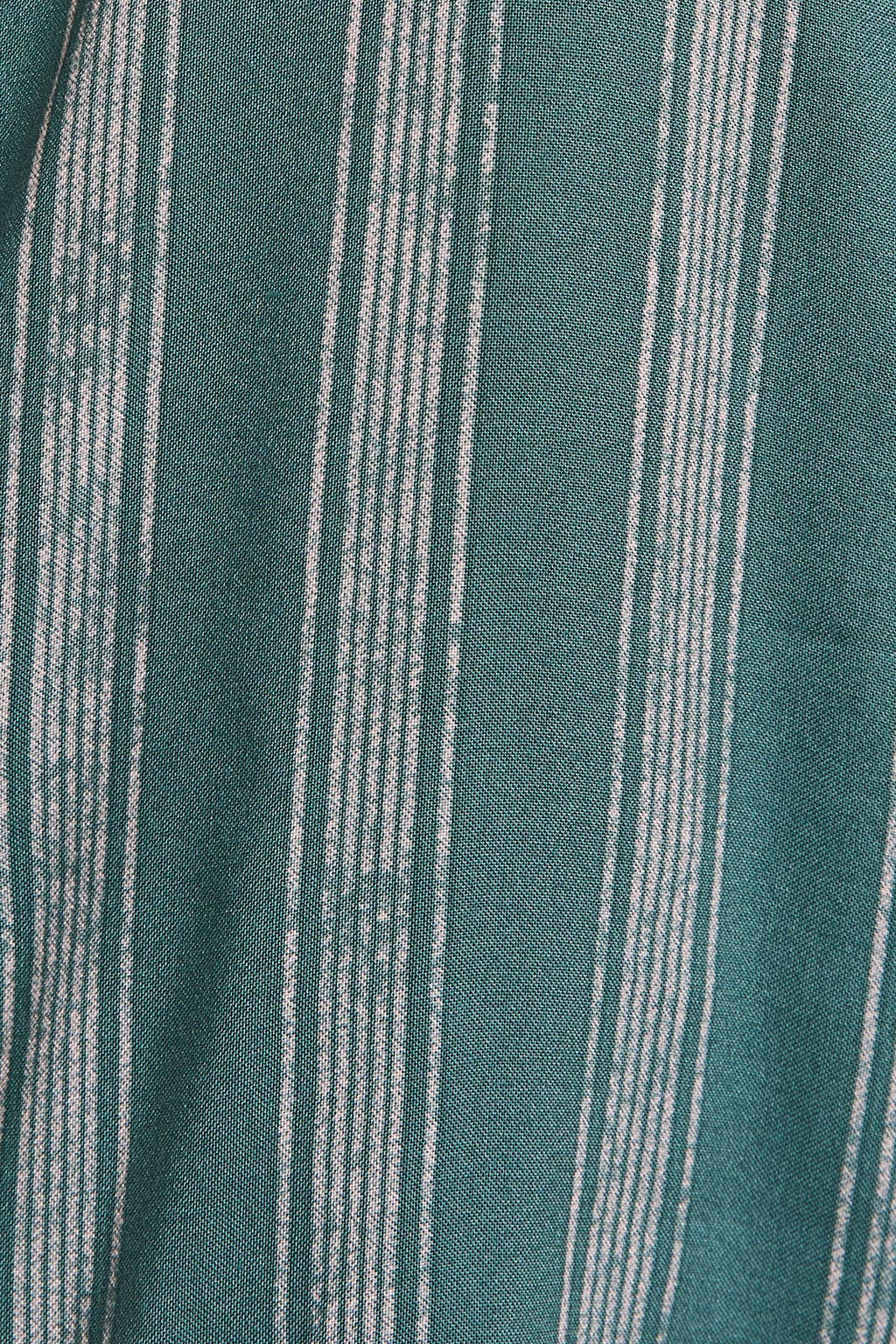Close up of green and cream striped ruffle top pants. 