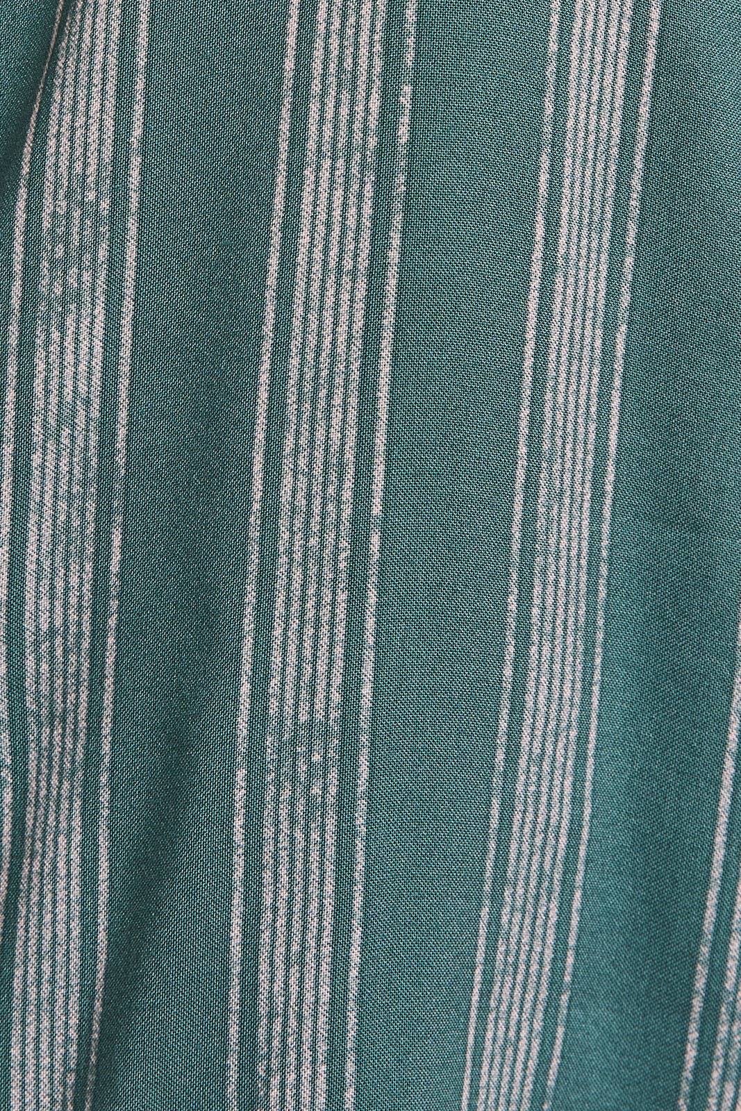 Close up of green and cream striped ruffle top pants. 