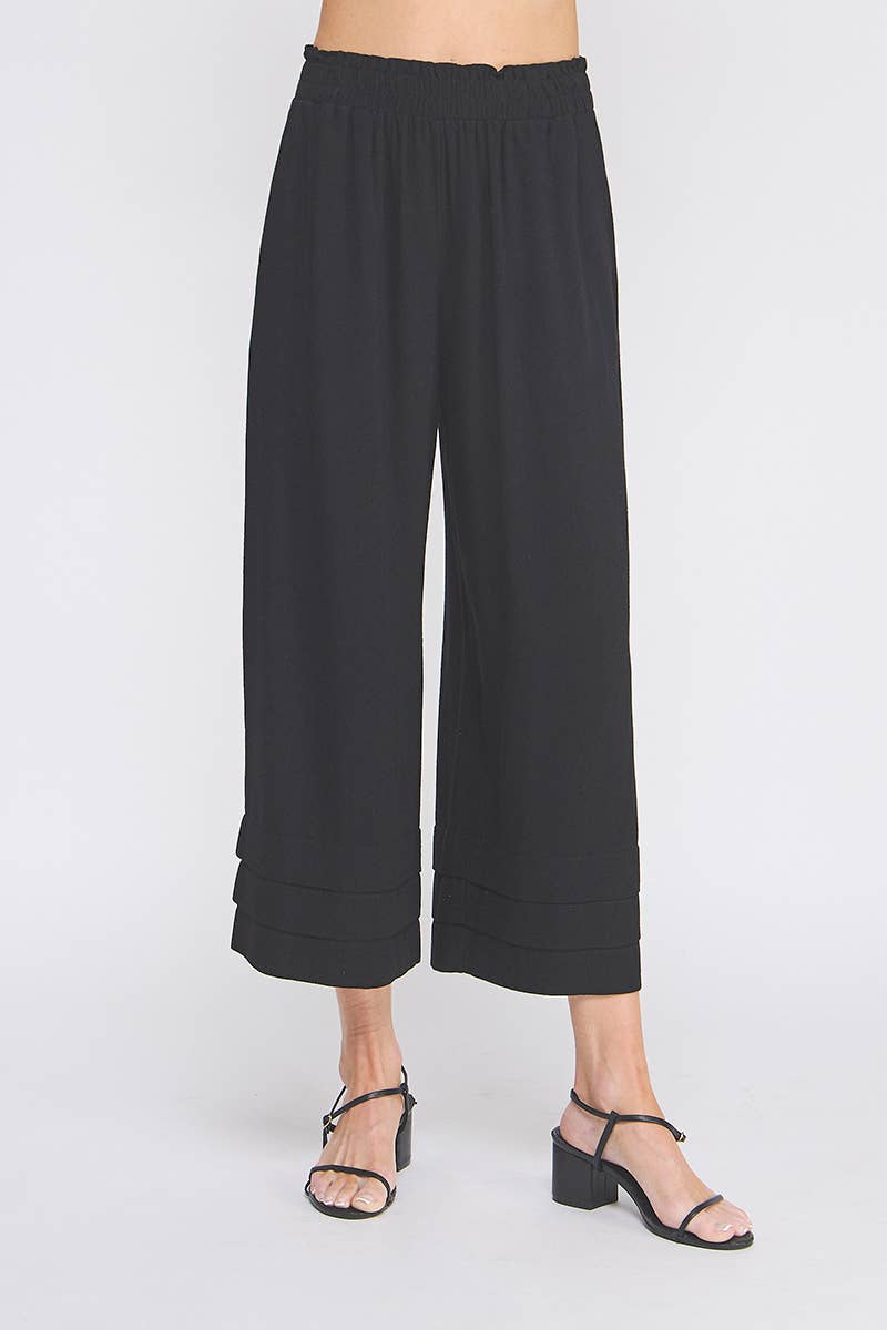 Black wide-leg pants worn by a person on a white background