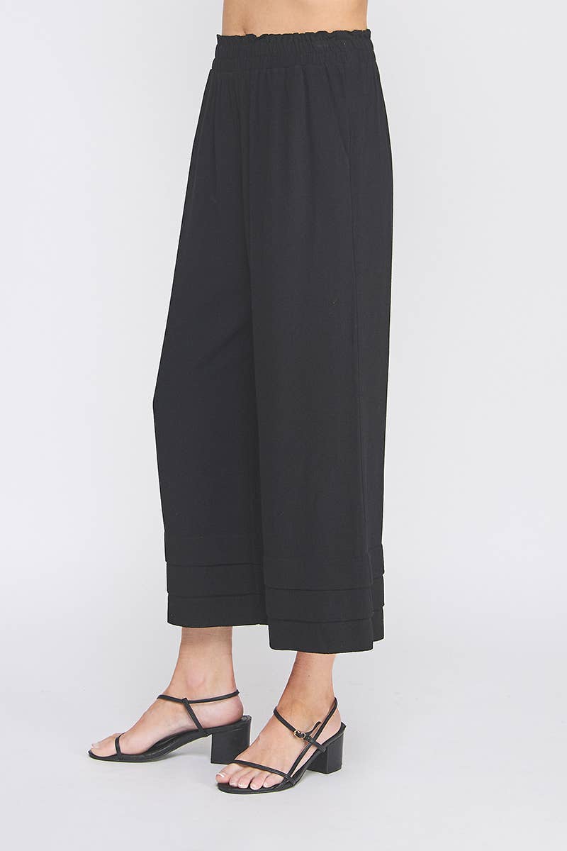 Black wide-leg pants worn by a person on a white background
