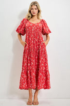 Woman wearing a red floral dress against a white background