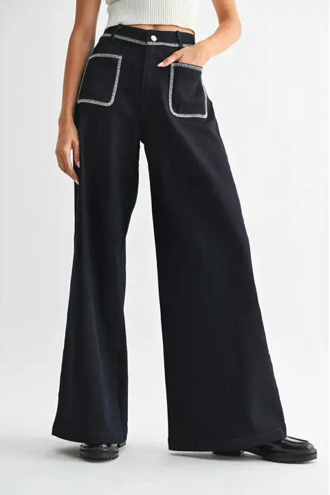 Women's dark denim wide-leg pants with white trim on a white background