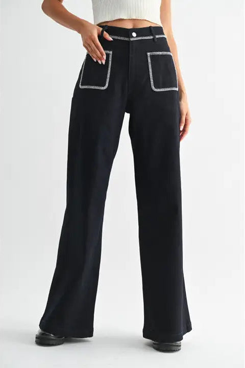 Women's dark denim high-waisted pants with white stitching on a white background
