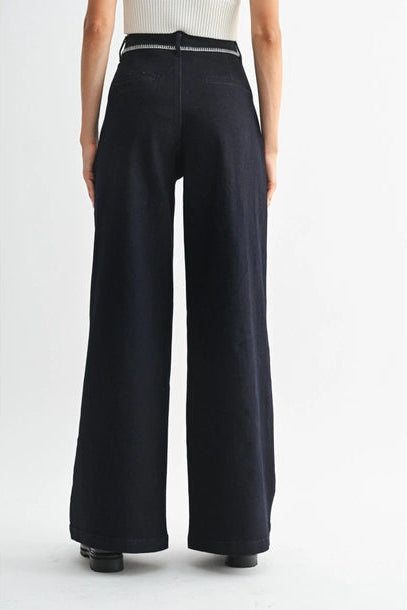 Women's dark denim wide-leg pants worn by a person on a white background