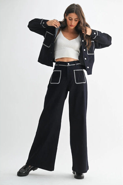 Woman wearing dark denim with a white top on a white background