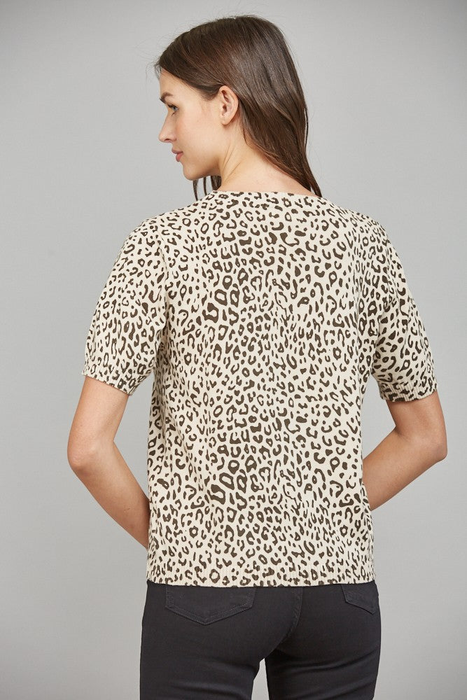 Back view of a woman wearing an animal print knit sweater against a gray background