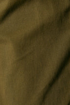 A close-up of olive green fabric with a visible woven texture and soft folds.