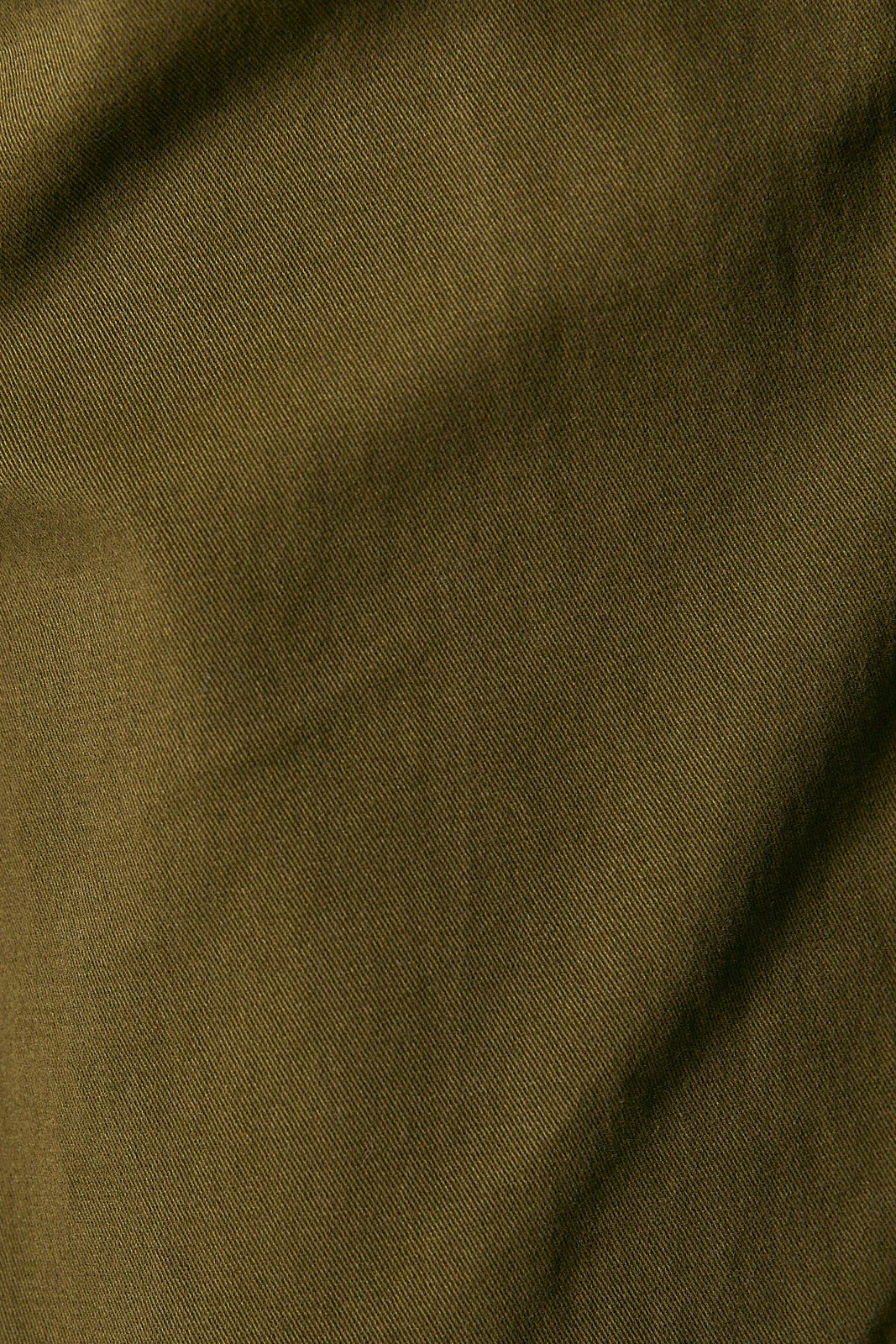 A close-up of olive green fabric with a visible woven texture and soft folds.