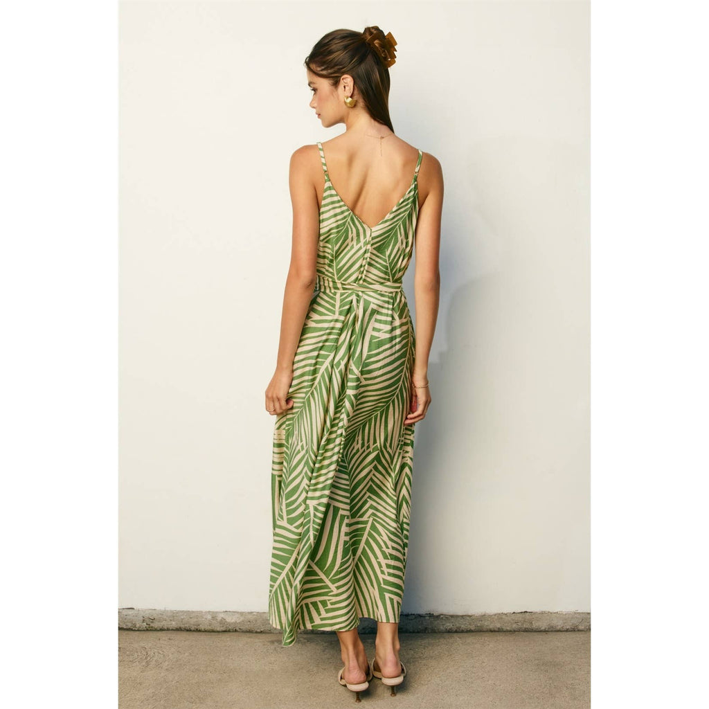 Woman wearing a sage and cream leaf patterned maxi dress against a plain background